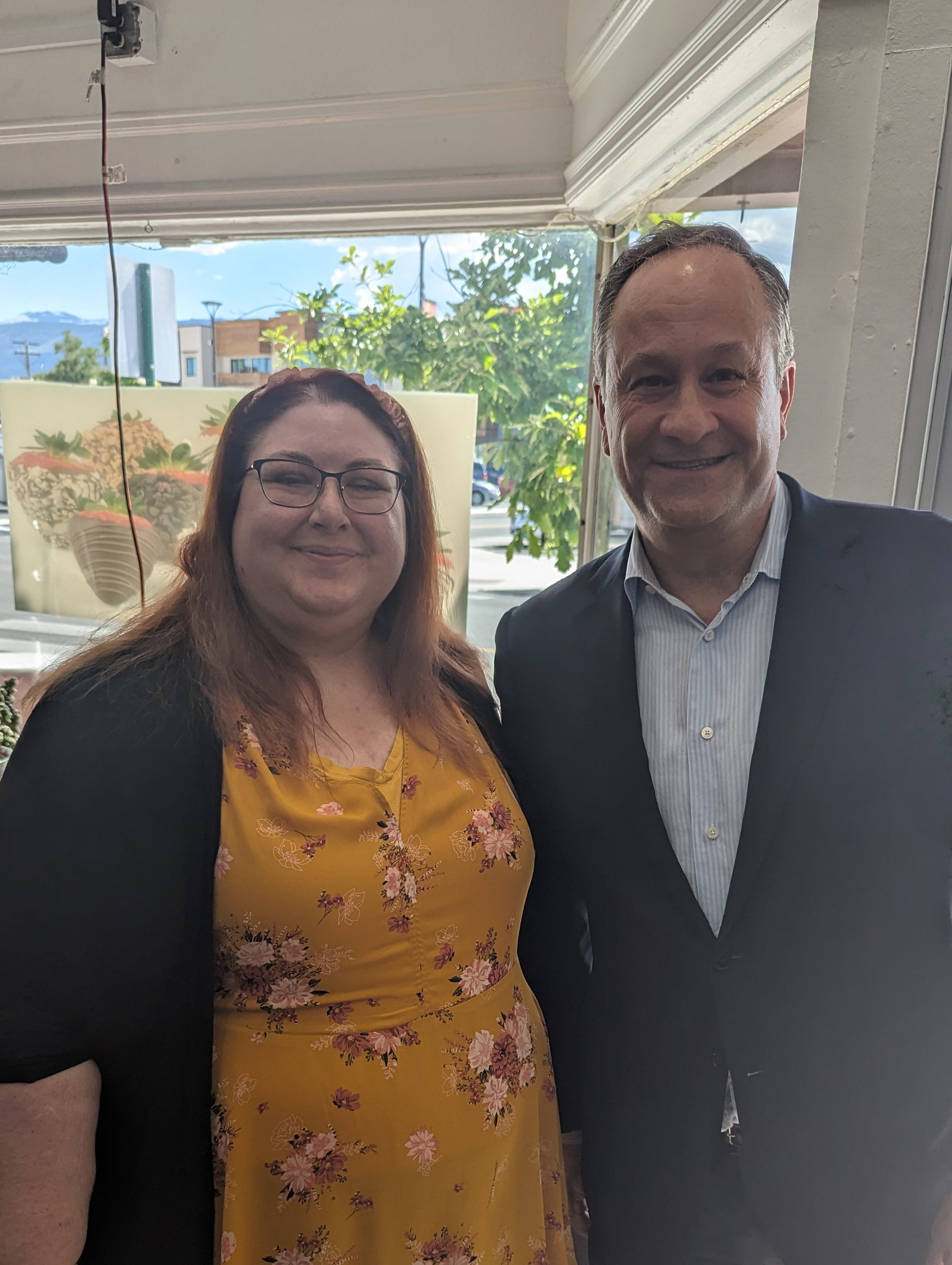 Picture is of Chair Cynthia King with Former Second Gentleman Doug Emhoff.
Cynthia is a 5 foot 6 inch chunky lady who usually smells like cookies and coffee. She is wearing a black jacket, yellow top with pink flowers, black skirt, has brown hair and glasses.
Former Second Gentleman Doug Emhoff is taller than Cynthia, slightly balding, medium build. wearing a black suit jacket, blue button down shirt, and black slacks.